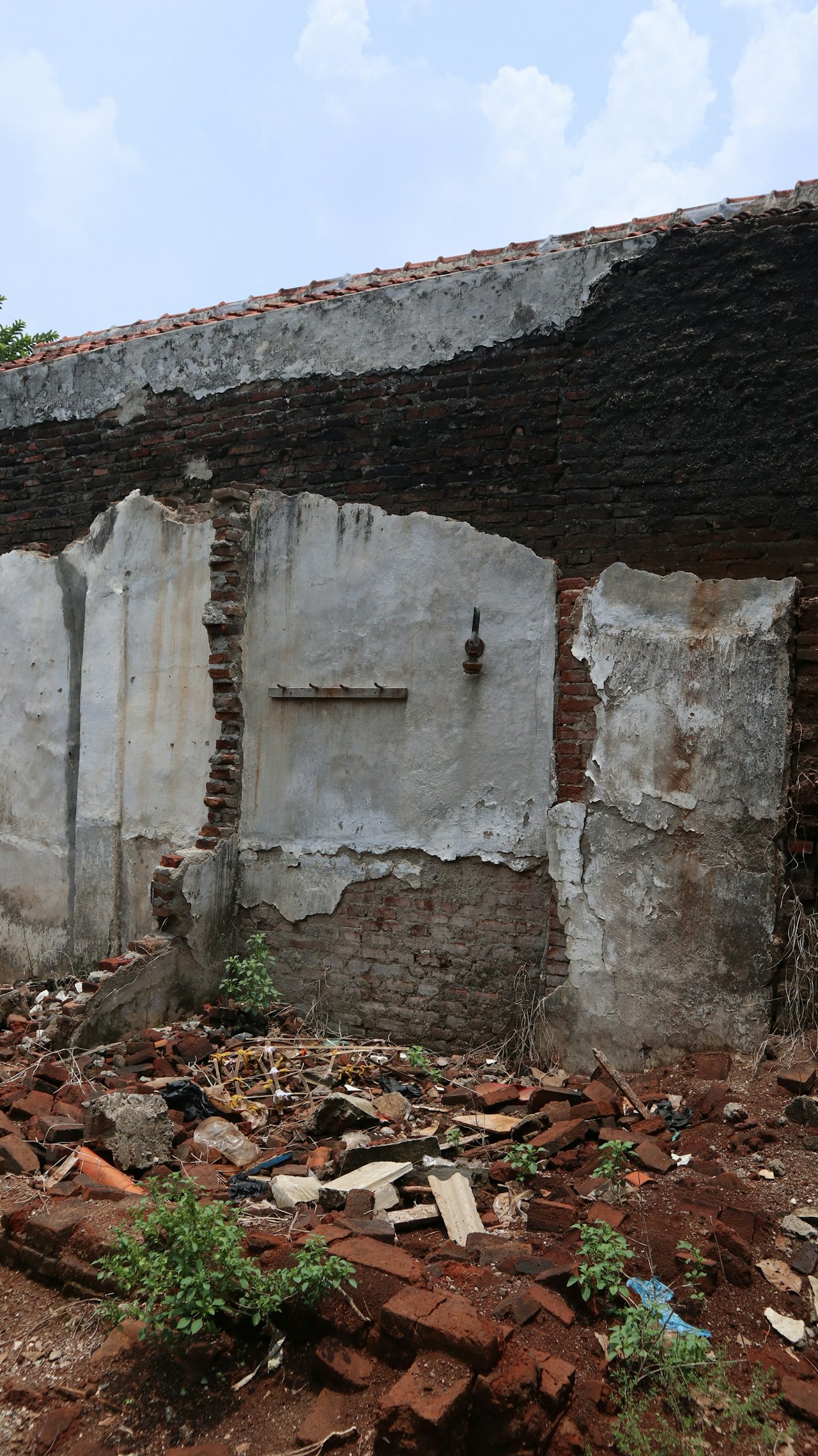 The remains of an old brick and stone wall with rubble at its base and overgrown vegetation, the kind of foundation detectorists look for when researching abandoned homestead sites