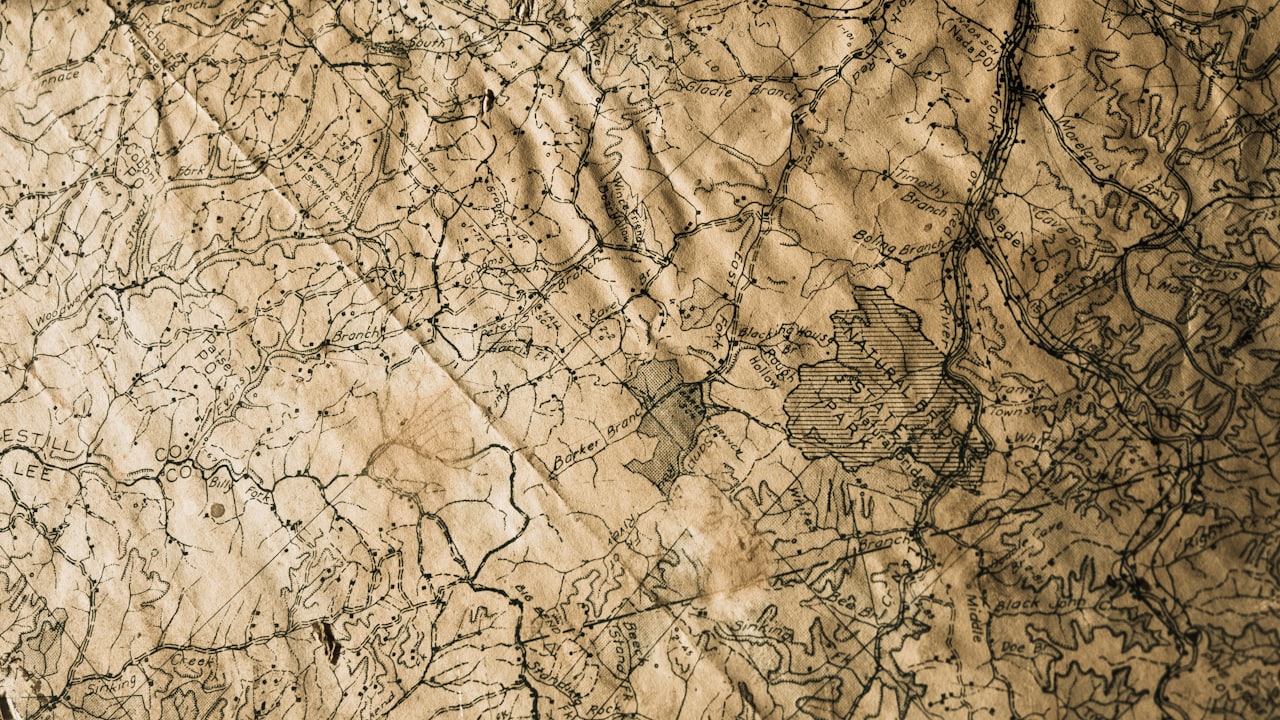 An aged crinkled topographic map showing terrain contours and place names